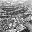 Aerial view of lower end of Canongate, also showing Regent Terrace towards top of photograph, Holyrood Palace at right, Holyrood Road, Meadow Flat Gas Holder Station at bottom, and Canongate heading to left