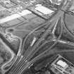 Oblique aerial view centred on the motorway interchange, taken from the NW.
