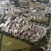 Oblique aerial view centred on the hospital with the chapel, hospital and school adjacent, taken from the SE.