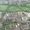 Oblique aerial view centred on the hospital with the chapel, hospital and school adjacent, taken from the NNW.