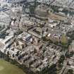 Oblique aerial view centred on the hospital with the chapel, hospital and school adjacent, taken from the SE.