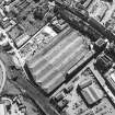 Oblique aerial view centred on the garage with the church and graveyard, New Street, Tolbooth Wynd and the Canongate adjacent, taken from the WNW.