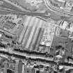 Oblique aerial view centred on the garage with the church and graveyard, New Street, Tolbooth Wynd and the Canongate adjacent, taken from the SE.