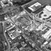 Oblique aerial view centred on the Scottish Parliament under construction with `Our Dynamic Earth¿ and palace adjacent, taken from the WNW.
