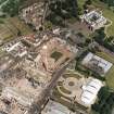 Oblique aerial view centred on the Scottish Parliament under construction with 'Our Dynamic Earth' and Holyrood Palace adjacent, taken from the SW.