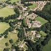 Oblique aerial view centred on the church, burial ground and village, taken from the W.