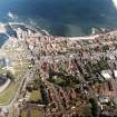 Oblique aerial view of the burgh and town with the harbour adjacent, taken from the W.