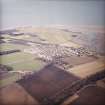 General oblique aerial view centred on the village with the golf course adjacent, taken from the E.