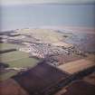 General oblique aerial view centred on the village with the golf course adjacent, taken from the E.