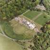 Oblique aerial view showing house, formal gardens, coach house and stables from SW.