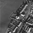 Oblique aerial view of Carrington Parish Church centred on a church with a general view of the burgh, taken from the SW.