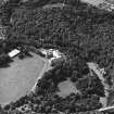 Oblique aerial view centred on the country house and garden with bridge adjacent, taken from the NE.