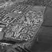 Oblique aerial view centred on the housing estate constructed on the site of two former settlements, taken from the NE.