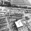 Oblique aerial view centred on the remains of the works with church and burial ground adjacent, taken from the N.