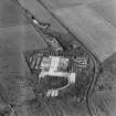 Oblique aerial view from S.  Some of the hangar support blocks for the airship sheds are visible. In the centre of the photograph are the surviving remains of the World War Two vehicle repair sheds and the concrete bases of several other ancillary buildings.