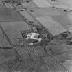 Oblique aerial view from SSW.  Some of the hangar support blocks for the airship sheds are visible. In the centre of the photograph are the surviving remains of the World War Two vehicle repair sheds and the concrete bases of several other ancillary buildings.