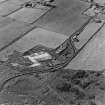 Oblique aerial view from SE.  Some of the hangar support blocks for the airship sheds are visible. In the centre of the photograph are the surviving remains of the World War Two vehicle repair sheds and the concrete bases of several other ancillary buildings.