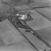 Oblique aerial view from NE.  Some of the hangar support blocks for the airship sheds are visible. In the centre of the photograph are the surviving remains of the World War Two vehicle repair sheds and the concrete bases of several other ancillary buildings.