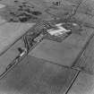 Oblique aerial view from NW.  Some of the hangar support blocks for the airship sheds are visible. In the centre of the photograph are the surviving remains of the World War Two vehicle repair sheds and the concrete bases of several other ancillary buildings.