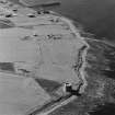 Oblique aerial view of Orkney, Hoy, Crockness Martello Tower, taken from the S.  Also visible is part of the Second World War Rinnigil barrage balloon gas production plant.