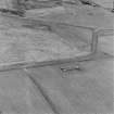 Oblique aerial photograph of part of Lyness Naval Oil Terminal taken from N showing footings of a large building.