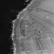 Oblique aerial view of the First World War Ness Battery, taken from the E.  Visible are the three open gun-emplacements and sunken magazines connected by rock-cut trenches.