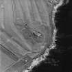 Oblique aerial view of the First World War Ness Battery, taken from the SW.  Visible are the three open gun-emplacements and sunken magazines connected by rock-cut trenches.  Also visible is the Second World War Links Battery.