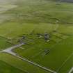 Oblique aerial view centred on the remains of the church and burial-ground, taken from the NE.