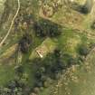 Oblique aerial view centred on the remains of the burial-ground and church, taken from the WNW.