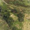 Oblique aerial view centred on the remains of the burial-ground and church, taken from the SW.