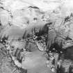 Oblique aerial view centred on the farmhouse, byre, farmsteading and the remains of the earthwork and farmstead, taken from the SW.