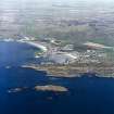 General oblique aerial view centred on the village and harbour with whisky distillery adjacent, taken from the SSE.