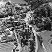 Oblique aerial view of Biggar centred on Biggar Church, churchyard, Moat Park Church and church hall, taken from the N.