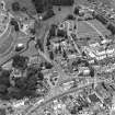 Oblique aerial view of Biggar centred on Biggar Church, churchyard, Moat Park Church and church hall, taken from the S.