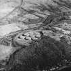 Oblique aerial view centred on the oil fuel depot with the farmsteading and military training camp adjacent, taken from the WNW.
