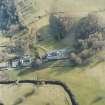 Oblique aerial view centred on the country house with stables and bridge adjacent, taken from the N.