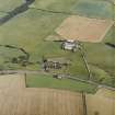Oblique aerial view centred on the farmsteading and the remains of the abbey, taken from the NNW.