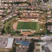 Oblique aerial view centred on the football stadium, taken from the SSW.