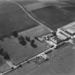 Oblique aerial view from SE with farm buildings.