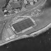 Oblique aerial view centred on the football ground with the school adjacent, taken from the SSW.