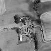 Oblique aerial view centred on the church and burial ground with manse, schoolhouse, farmsteading and road bridge adjacent, taken from the WSW.