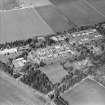 Oblique aerial view centred on the hospital and offices, taken from the SSW.