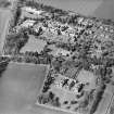 Oblique aerial view centred on the hospital and offices, taken from the SSE.