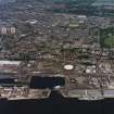 General oblique aerial view of Dundee, the dock, gasworks and football stadiums, taken from the SE.
