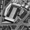 Oblique aerial view centred on the football stadium with jute works adjacent, taken from the W.