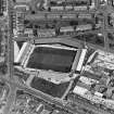 Oblique aerial view centred on the football stadium with jute works adjacent, taken from the S.