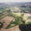 General oblique aerial view looking across the country house, ponds, stable block and farmsteading towards the Grampian mountains, taken from the SE.