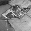 Oblique aerial view centred on the farmhouse and farmsteading, taken from the SW