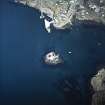 Oblique aerial view centred on the tower-house with the pier and town adjacent, taken from the S.