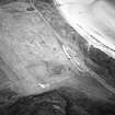 Oblique aerial view centred on the remains of the church and burial ground, taken from the WSW.